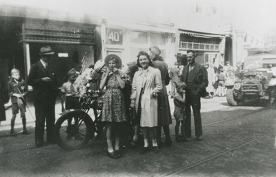 875688 Afbeelding van enkele omstanders bij een motorrijder op de Voorstraat te Utrecht, tijdens de intocht van de ...